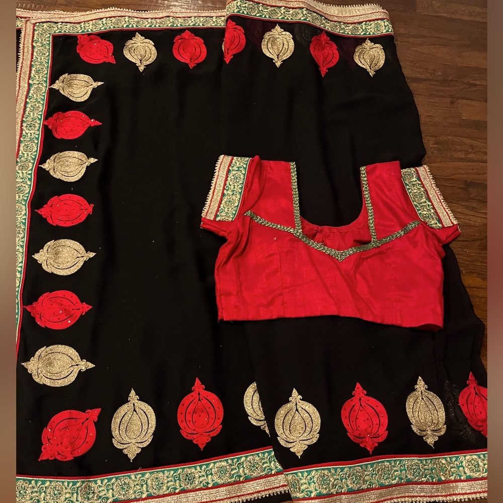 Gorgeous black saree contrast red blouse. Embroidered red and gold motifs